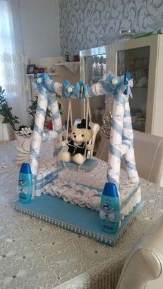 a teddy bear sitting on top of a blue and white cake with decorations around it