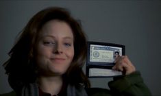 a woman holding up an id card in front of her face