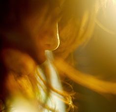 a blurry photo of a woman's face in the dark with light shining on her