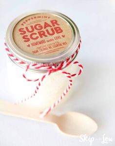 sugar scrub sitting on top of a spoon next to a jar with red and white twine