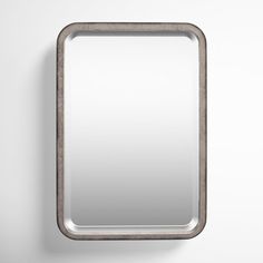 an empty mirror hanging on the wall with a metal frame and silver trim around it