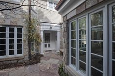 an outside view of a house with windows and stone walkway leading to the front door