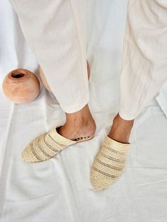 We fell in love with these lightweight shoes and now we want to share this love with you! The slippers are handcrafted in Morocco following old traditions. It takes one day to finish one pair of shoes: That's slow fashion! The upper material is made from palm leaves (raffia), the outer sole is in structured anti-slippery rubber and the inner sole is in dark brown vegan leather with logo embossing. The design is unique and furthermore super comfortable. We don't wanna take them off anymore. ~ Handmade in Morocco. ~ If you are between two sizes, we recommend you choose the larger one, as they run a little smaller. EU 36: US 5 / UK 3 EU 37: US 6 / UK 4 EU 38: US 7 / UK 5 EU 39: US 8 / UK 6 EU 40: US 9 / UK 7 EU 41: US 10 / UK 8 EU 42: US 11 / UK 9 Beige Slip-on Mules With Woven Sole, Cream Closed Toe Slip-ons, Beige Slippers With Leather Sole, Beige Slip-on Mules With Rubber Sole, Beige Slippers With Leather Sole And Flat Heel, Beige Closed Toe Mules With Rubber Sole, Handmade Natural Slippers With Round Toe, Natural Woven Sole Slip-on Clogs, Natural Color Slip-on Clogs With Woven Sole