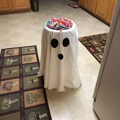 a white table with black polka dots on it and a ghost cloth covering the top