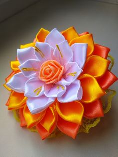 an orange and white flower on top of a table