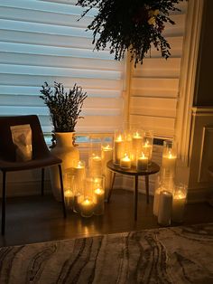 many candles are lit in front of a window