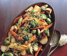 a plate filled with vegetables on top of a wooden table next to a serving dish