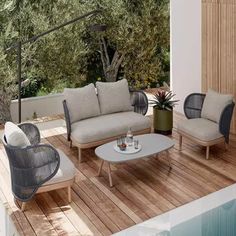 an outdoor living room with wooden floors and white furniture on the decking area next to a swimming pool