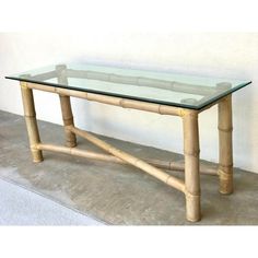 a glass and bamboo table on concrete floor