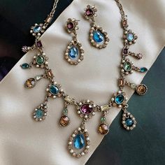 This French 1700s inspired necklace features vintage cut crystal stones in exotic tourmaline shades of blues, amethyst, champagne, green and seed pearls. The stones are in perfect, never used condition, acquired when I first designed and produced the necklace for the Victoria & Albert Museum. Each of the elements is exquisitely sculptured and joined to create a fluid collar in the Regency style. It is titled Juliette for the woman who inspired it -- Juliette Recamier -- whose famed Paris salon w