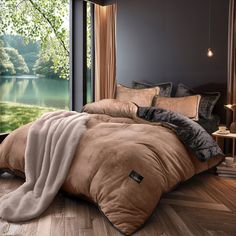 a large bed sitting next to a window in a room with wooden floors and walls