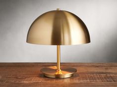 a gold lamp sitting on top of a wooden table