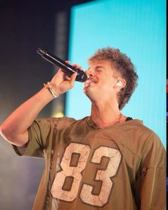 a man singing into a microphone on stage