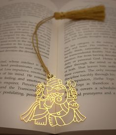 an open book with a laser cut christmas ornament hanging from it's side