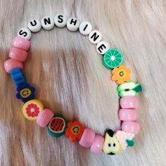 a close up of a bracelet made out of beads with fruit and vegetables on it