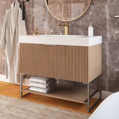 a bathroom with marble walls and flooring next to a white bathtub in front of a round mirror