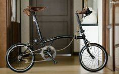 a bike parked in front of a door on a wooden floor next to an open doorway