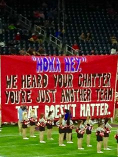 a group of cheerleaders standing in front of a large banner that reads, we heard your charter you're just another team at best mate