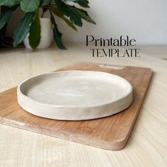 a white plate sitting on top of a wooden cutting board next to a potted plant