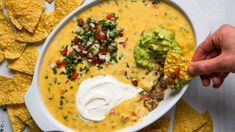 a bowl of quesadilla soup with tortilla chips and guacamole