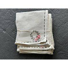 four napkins with embroidered flowers on them