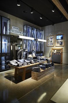 the interior of a clothing store with lots of items on display in front of large windows