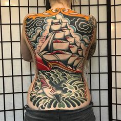 the back of a woman's body with tattoos on it