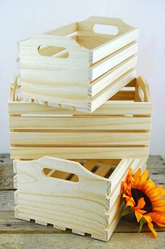 three wooden boxes with handles and two sunflowers