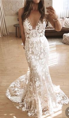 a woman is taking a selfie in her wedding dress while standing on the floor