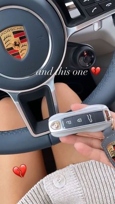 a woman holding a cell phone while sitting in a car