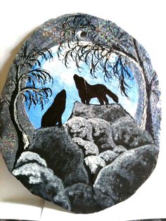 a black and white plate with two wolfs sitting on rocks in the night sky