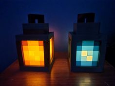 two lit cubes sitting on top of a wooden table