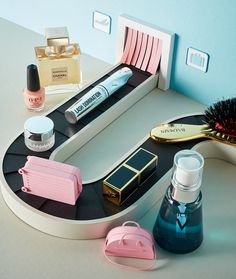 various beauty products are arranged on a vanity mirror with makeup and hairbrushes in the foreground