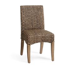 a woven chair with wooden legs on a white background