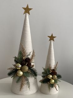 two white christmas trees decorated with gold ornaments