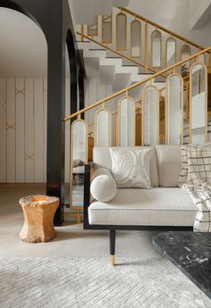 a white couch sitting in front of a wooden table on top of a carpeted floor