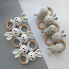 several knitted mice are sitting next to each other on the table with wooden rings