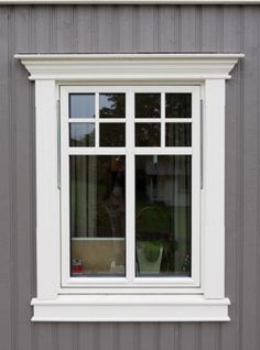 a white window on the side of a gray building