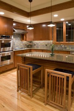 a kitchen with wooden cabinets and granite counter tops, along with an island in the middle