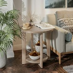 a living room with a couch, table and potted plant on the floor next to it