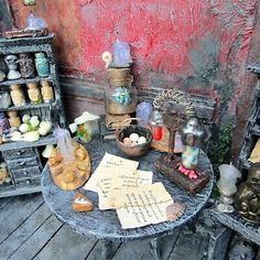 a table topped with lots of assorted items and writing on paper next to a red wall