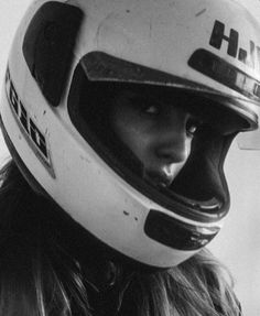 black and white photograph of a woman wearing a helmet with the word hh on it