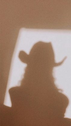 the shadow of a person wearing a cowboy hat