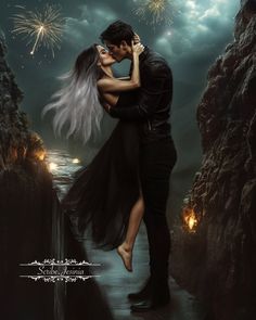 a man and woman kissing in front of fireworks on the night sky with dark clouds