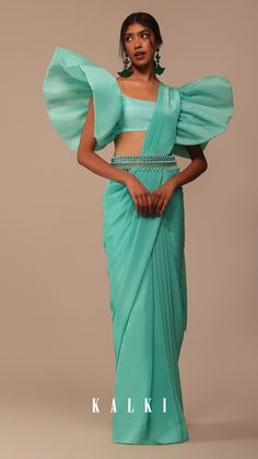 Embrace the beauty of nature with our aqua blue crepe saree paired with an organza frilled blouse. The organza blouse steals the spotlight with its modern appeal offering a unique round neckline and fancy sleeves. The set is further adorned with an embroidered belt featuring exquisite cutdana salli and pearl work. EVENT - Perfect for cocktail parties festive celebrations and special occasions. Fancy Sleeves, Pearl Work, Organza Blouse, Frill Blouse, Embroidered Belt