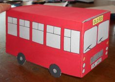 a paper model of a red bus on a table