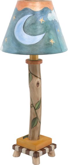 a lamp that is sitting on top of a wooden stand with a blue sky and stars painted on it