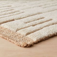 an area rug on the floor with white and beige colors, including one in the middle