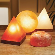 three different types of lights sitting on top of a wooden table next to each other