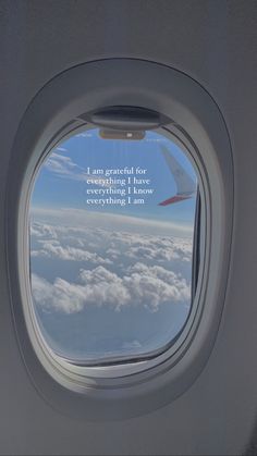 an airplane window with a view of the clouds and sky from it's inside